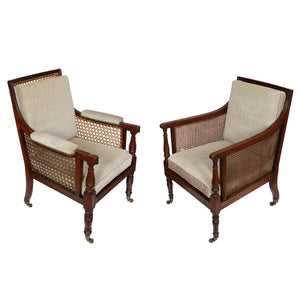 NEWLY REUPHOLSTERED REGENCY CANED LIBRARY ARM CHAIRS, AN ALMOST PAIR