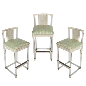SET OF THREE MID CENTURY LUCITE AND RATTAN BARSTOOLS WITH QUADRILLE LAMINATED UPHOLSTERY