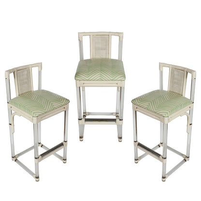 SET OF THREE MID CENTURY LUCITE AND RATTAN BARSTOOLS WITH QUADRILLE LAMINATED UPHOLSTERY