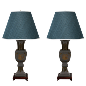 PAIR OF JAMES MONT STYLE BRASS AND BRONZE LAMPS WITH RAISED ASIAN MOTIF DETAIL AND WOOD BASE